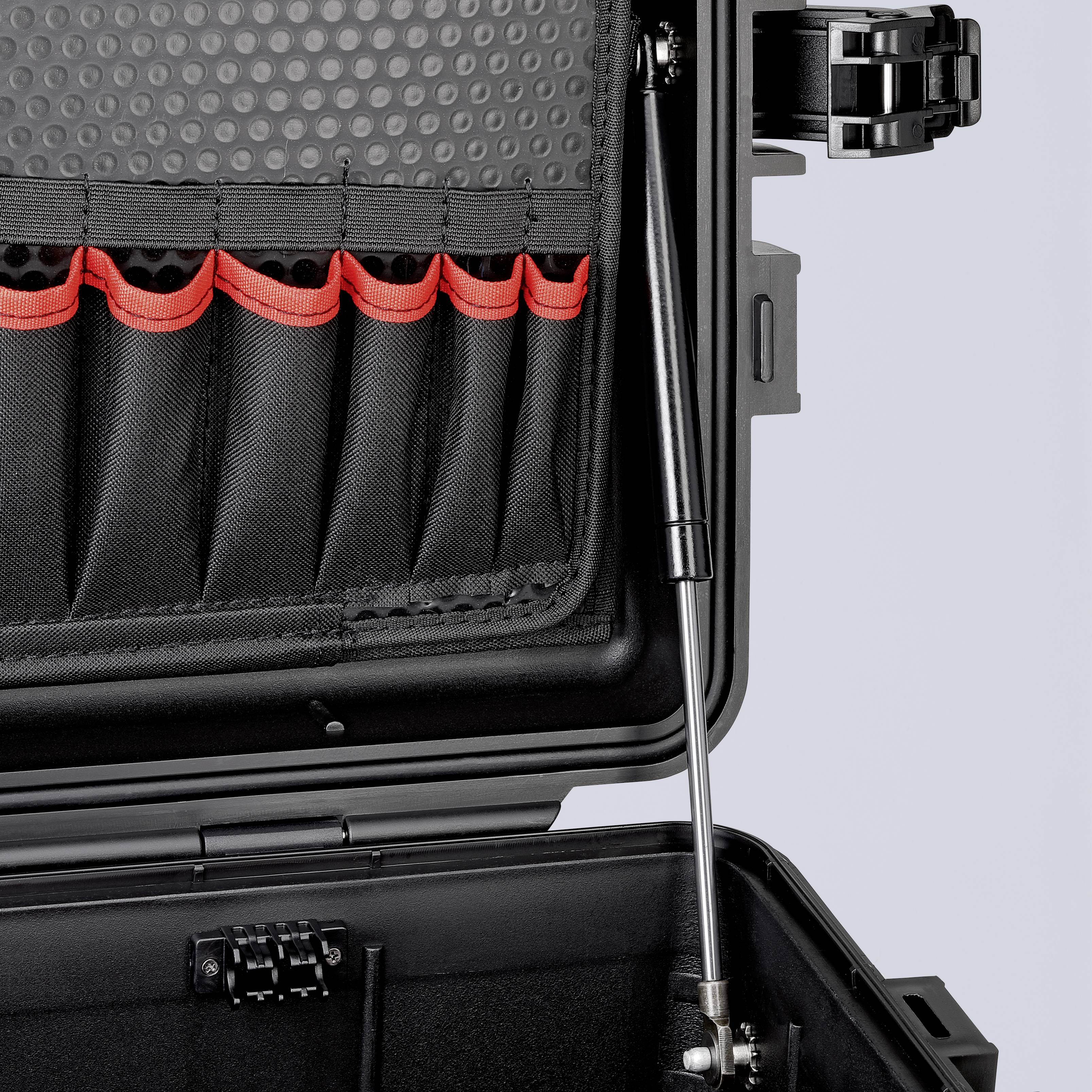 Ein offener schwarzer Koffer mit Polsterung und roten Taschen innen. Ideal zum organisierten Transport sensibler Geräte.