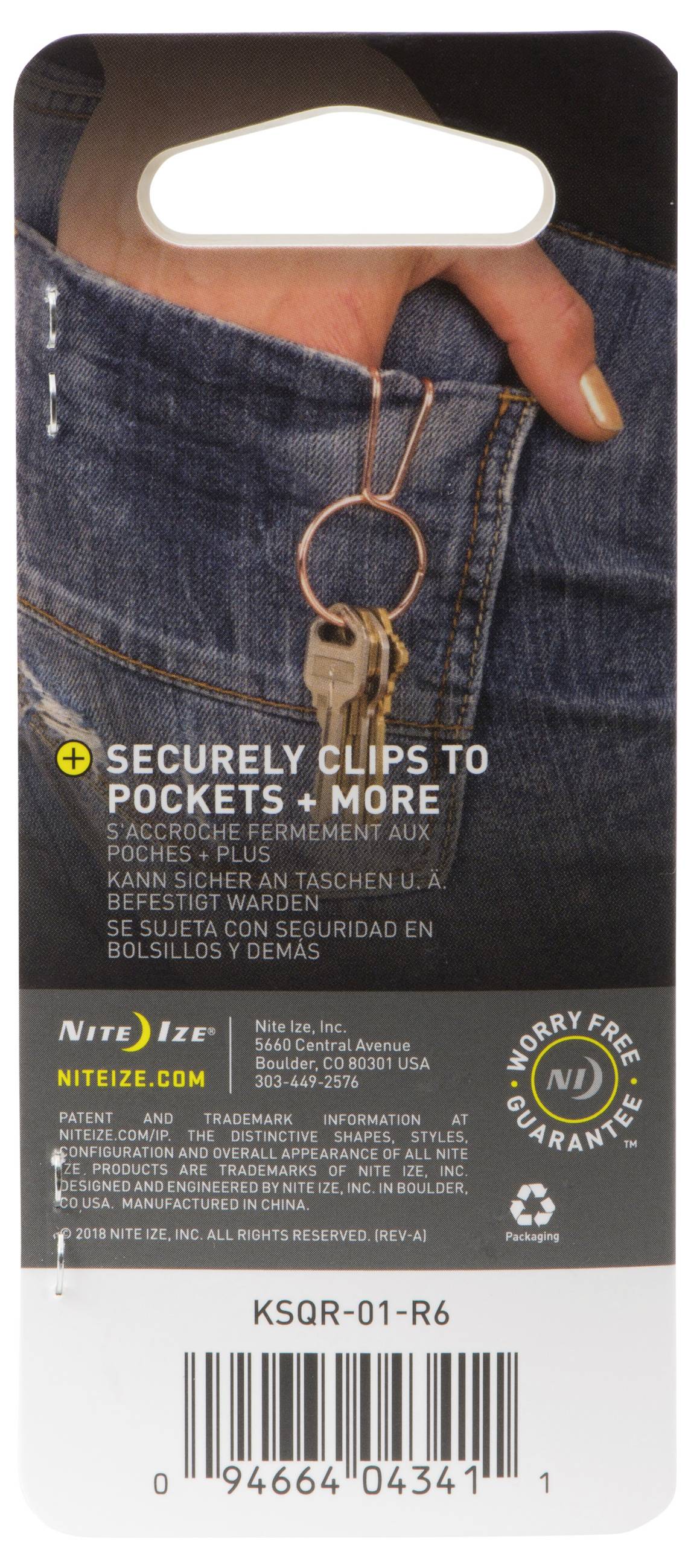 Eine Hand befestigt ein silbernes Werkzeug an einer blauen Jeans-Tasche. Der Text lautet: „Sicher an Taschen und mehr befestigbar.