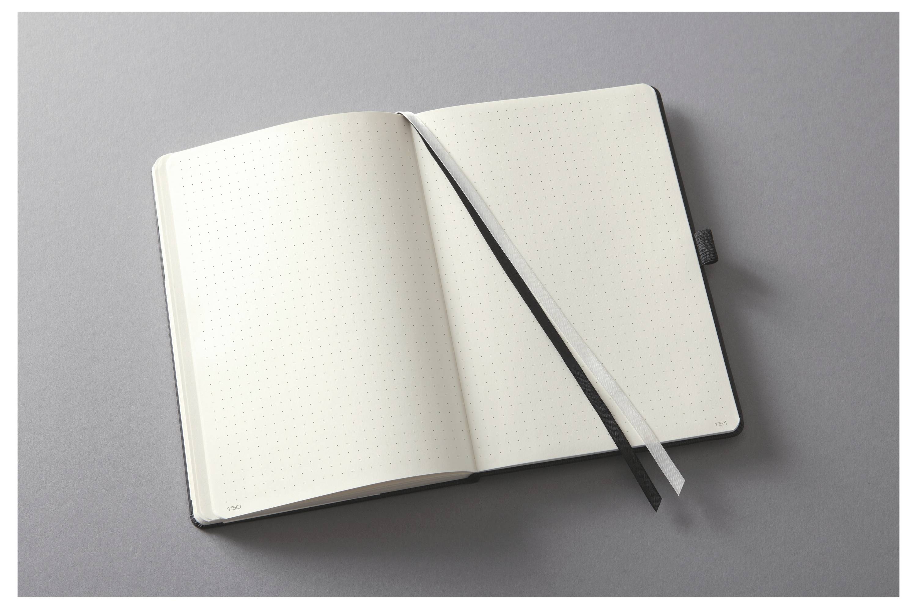 Leeres gepunktetes Notizbuch mit Bandlesezeichen auf grauem Hintergrund.