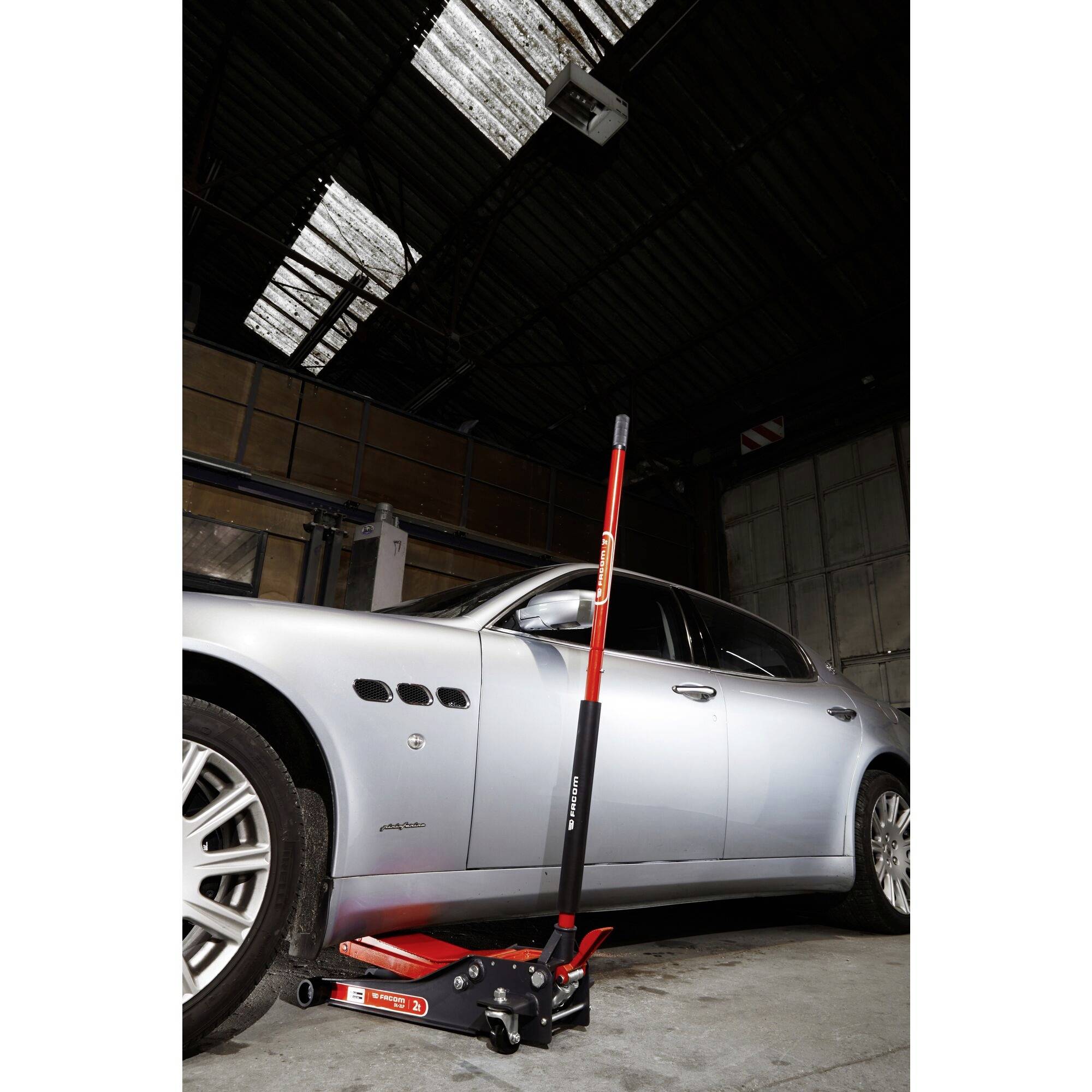 Auto in Garage wird mit hydraulischem Wagenheber angehoben.