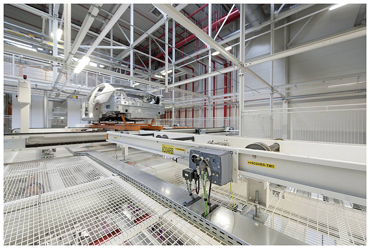 Eine leere Autofabrik mit einem unvollständigen Fahrzeug auf einem Förderband in einem modernen, gut beleuchteten Industriegebäude.