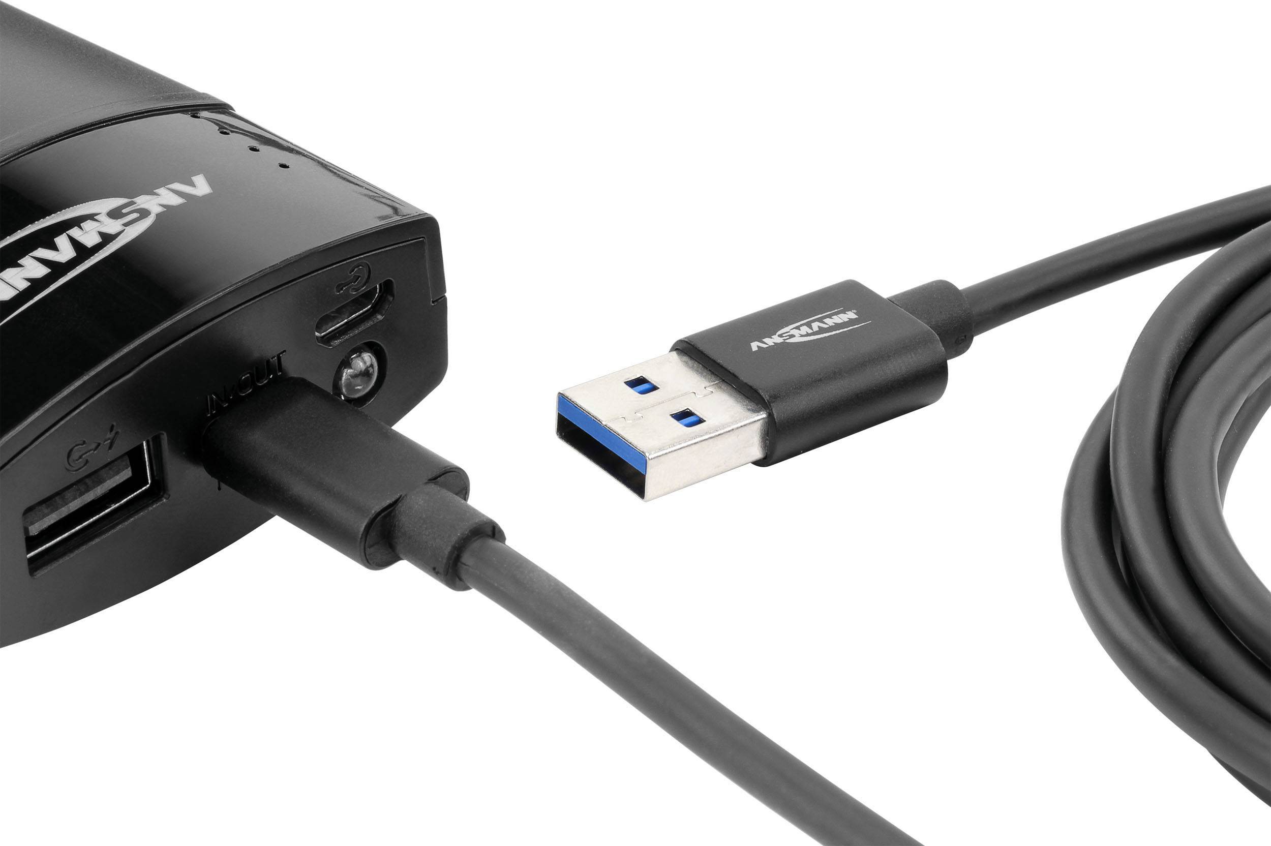 Ein schwarzes USB-Kabel ist an ein elektronisches Gerät angeschlossen. Das Kabel endet in einem USB-Stecker, erkennbar an der blauen Innenfarbe.
