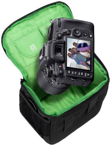 Eine Digitalkamera sitzt in einer geöffneten Kameratasche. Auf dem Bildschirm der Kamera ist ein Foto von einer Gruppe fröhlicher Menschen.