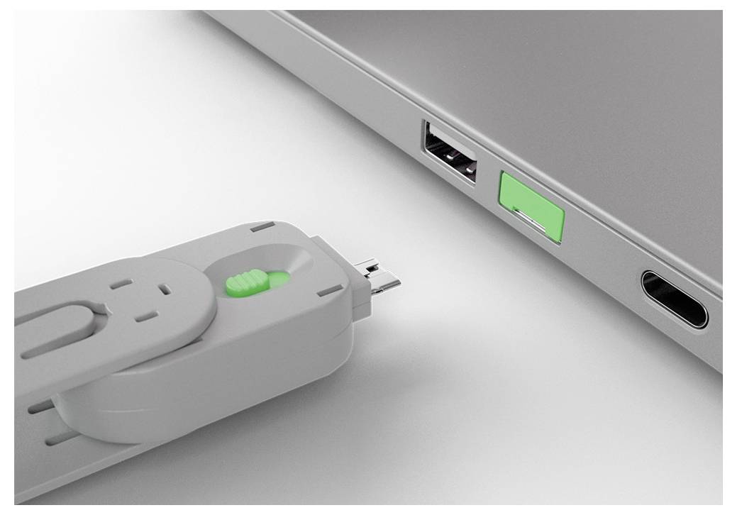 Nahaufnahme eines USB-Sticks, der in einen USB-Anschluss eines Laptops neben einem anderen Anschluss und einer grünen Anzeigelampe eingesteckt wird.