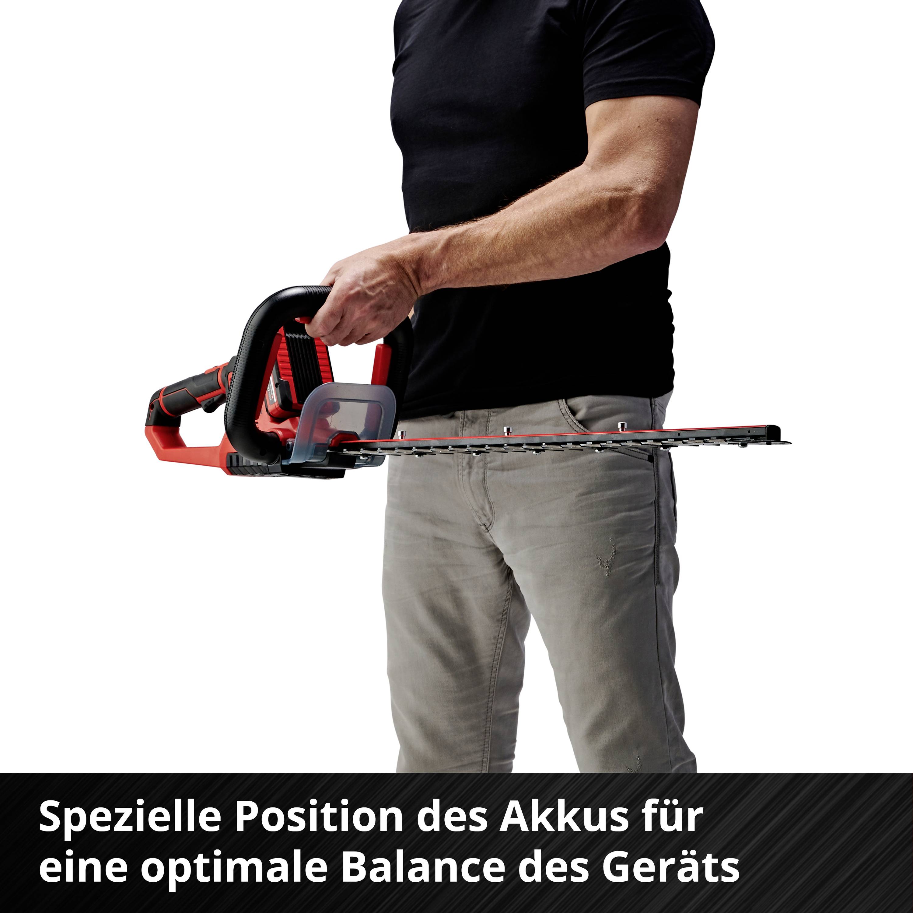 Ein Mann hält eine Kettensäge mit der Beschreibung 'Spezielle Position des Akkus für eine optimale Balance des Geräts'.