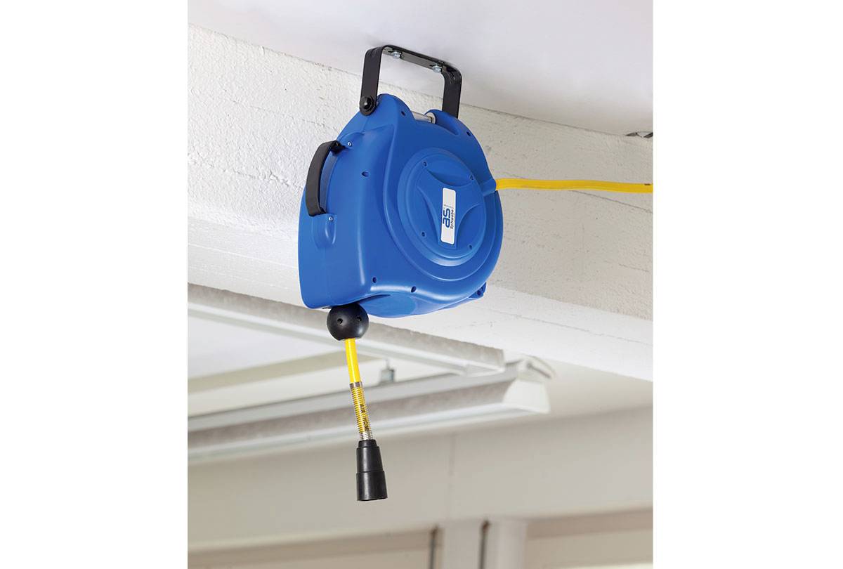 Eine blaue einziehbare Druckluftschlauchrolle ist an der Decke montiert, mit einem gelben Schlauch, der nach unten hängt. Die Düse des Schlauchs ist sichtbar.