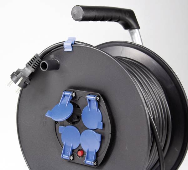 Eine schwarze Kabeltrommel mit langem Kabel und vier blauen Steckdosenabdeckungen. Ein Griff oben erleichtert den Transport.