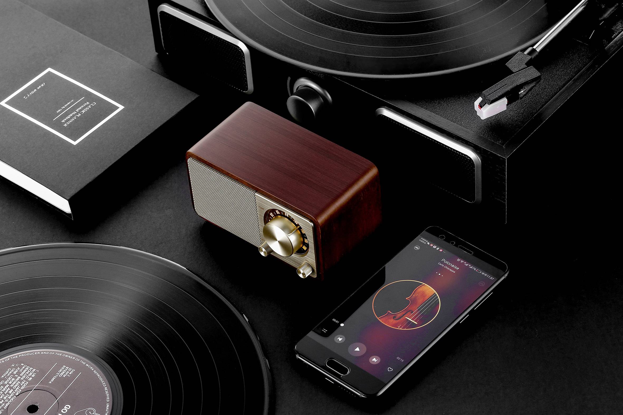 Schwarze Schallplatten, ein Holzlautsprecher und ein Smartphone zeigen Musik in einem eleganten Schwarz-Weiß-Setup.