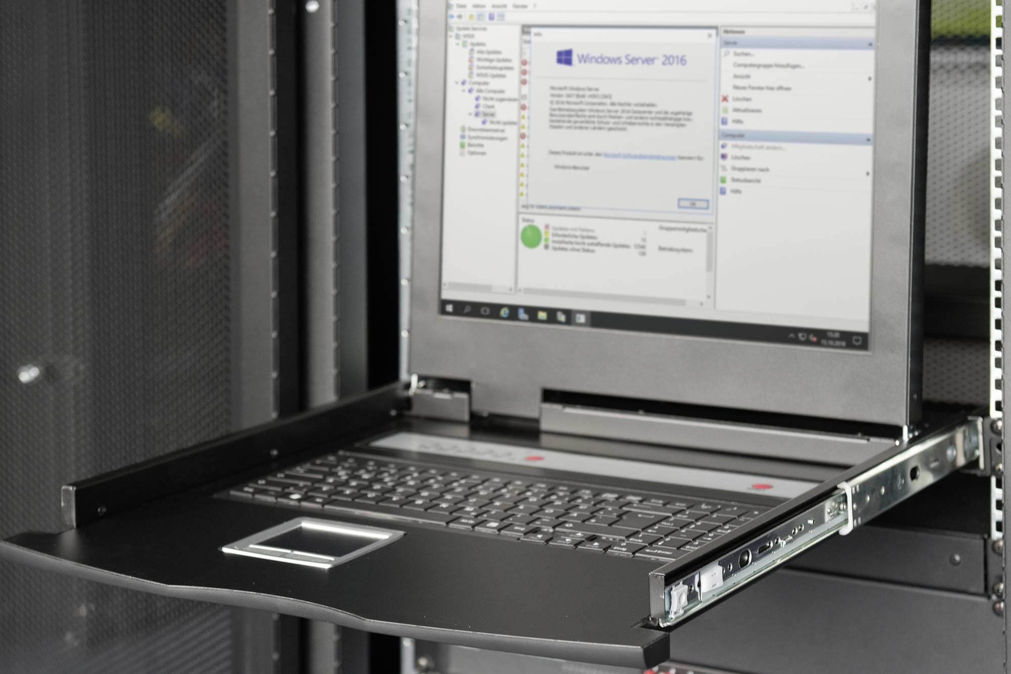 Ein geöffneter KVM-Switch in einem Server-Rack zeigt eine Windows Server 2016-Oberfläche auf dem Bildschirm, bereit zur Verwaltung.