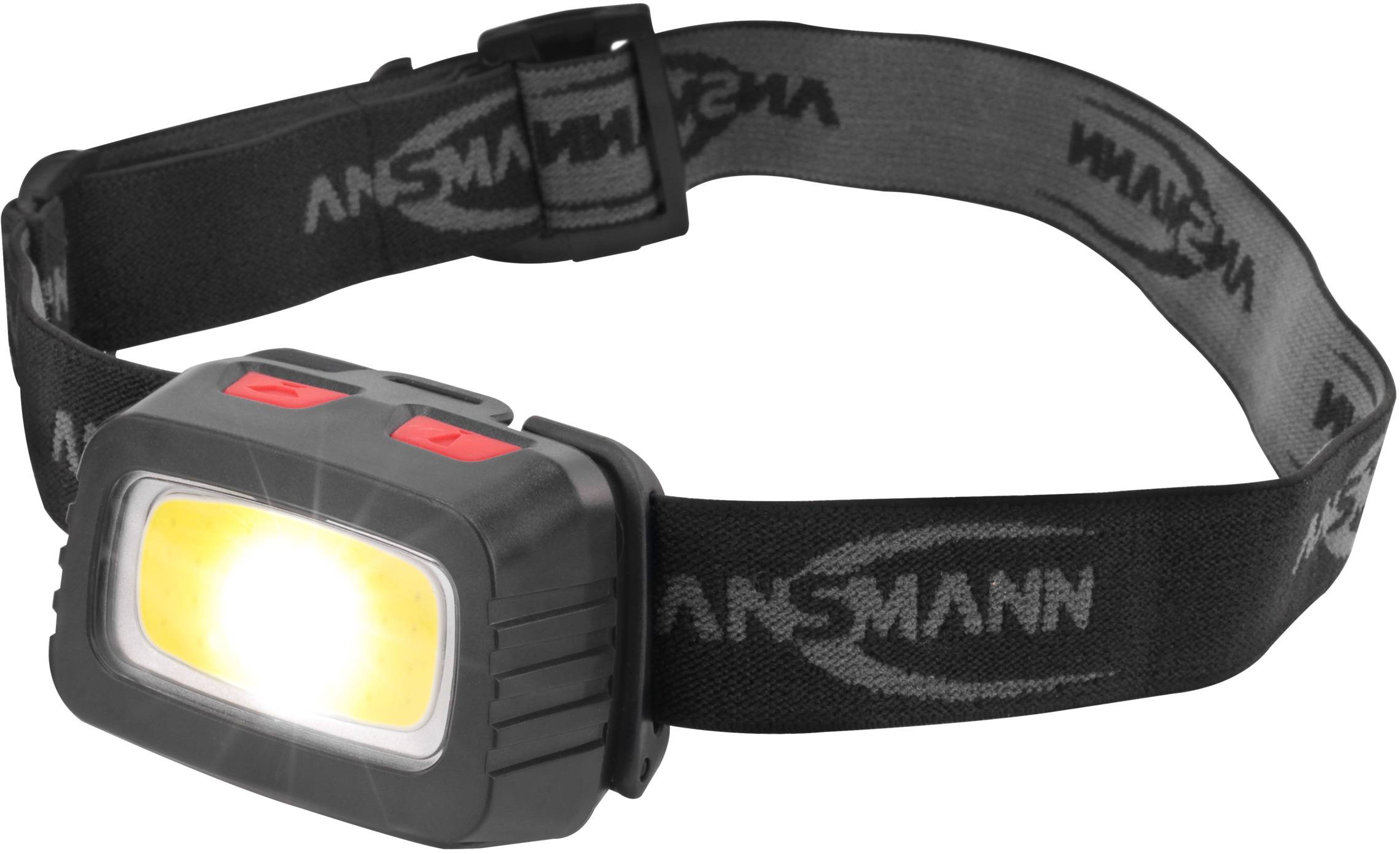 Eine schwarze Stirnlampe mit einem leuchtenden gelben Licht vorne und einem verstellbaren Band mit der Aufschrift 'ANSMANN'.