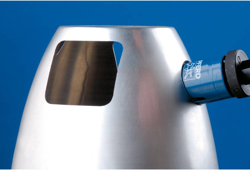 Ein silberner Metallzylinder mit einem rechteckigen Ausschnitt und einer blauen Vorrichtung auf der rechten Seite vor blauem Hintergrund.