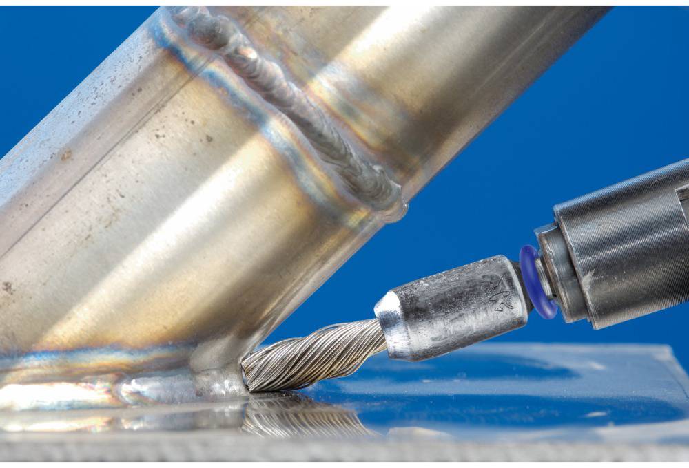 Metallstange wird präzise mit einem Schweißwerkzeug bearbeitet. Der Fokus liegt auf der Verbindung, die glänzend und sorgfältig geschweißt ist.