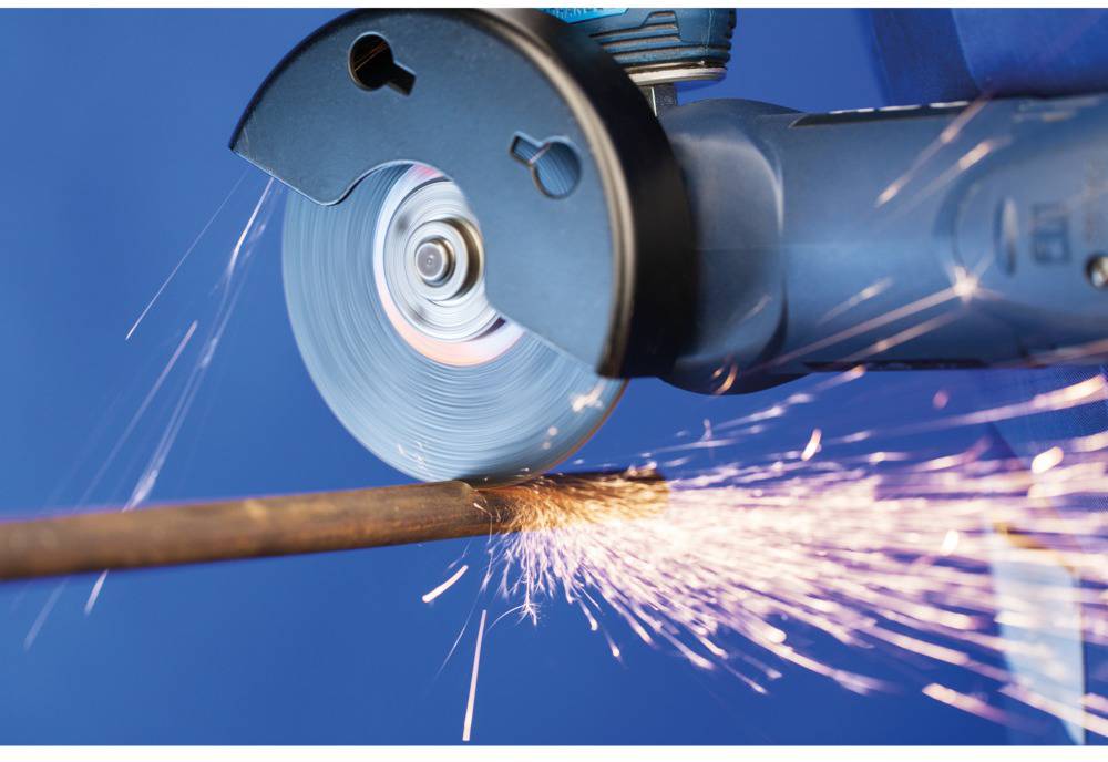 Schleifmaschine, die Funken sprüht, während sie ein Metallrohr schneidet. Das Bild zeigt die Dynamik der Funken und die blaue Maschine.