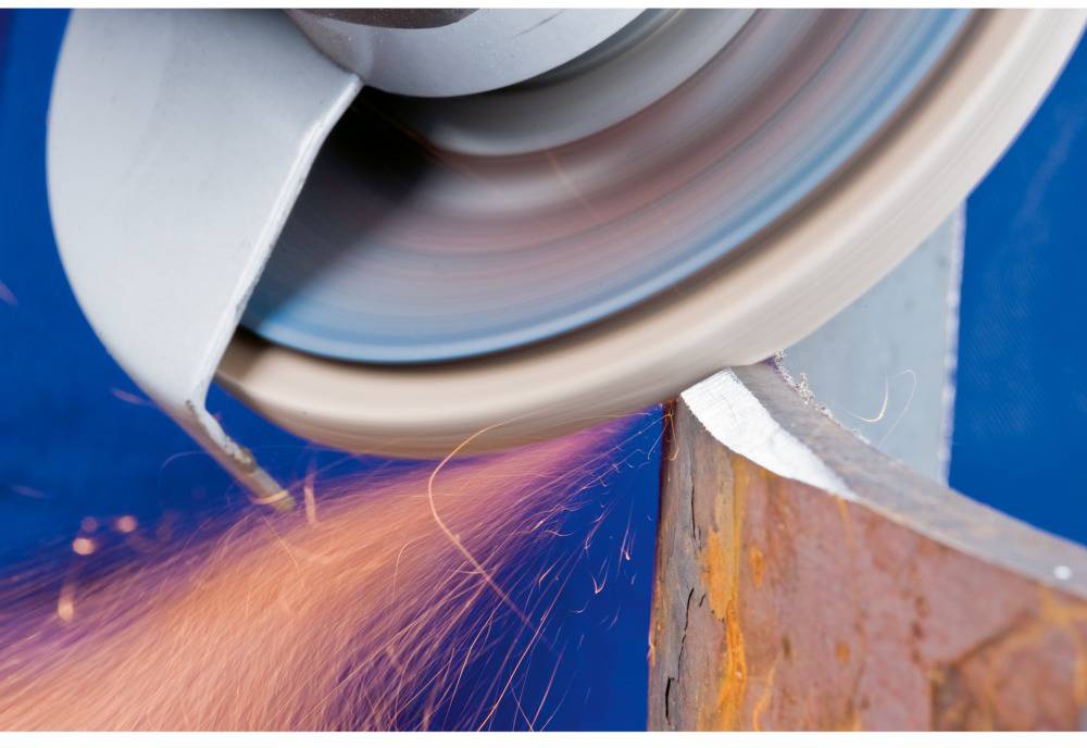 Ein Schleifwerkzeug erzeugt Funken, während es Metall bearbeitet. Der Hintergrund ist blau, das Funkenmuster orange und dynamisch.
