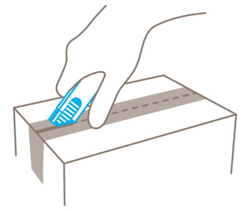 Eine Hand hält einen Boxcutter und schneidet ein Paketband auf einem Karton.