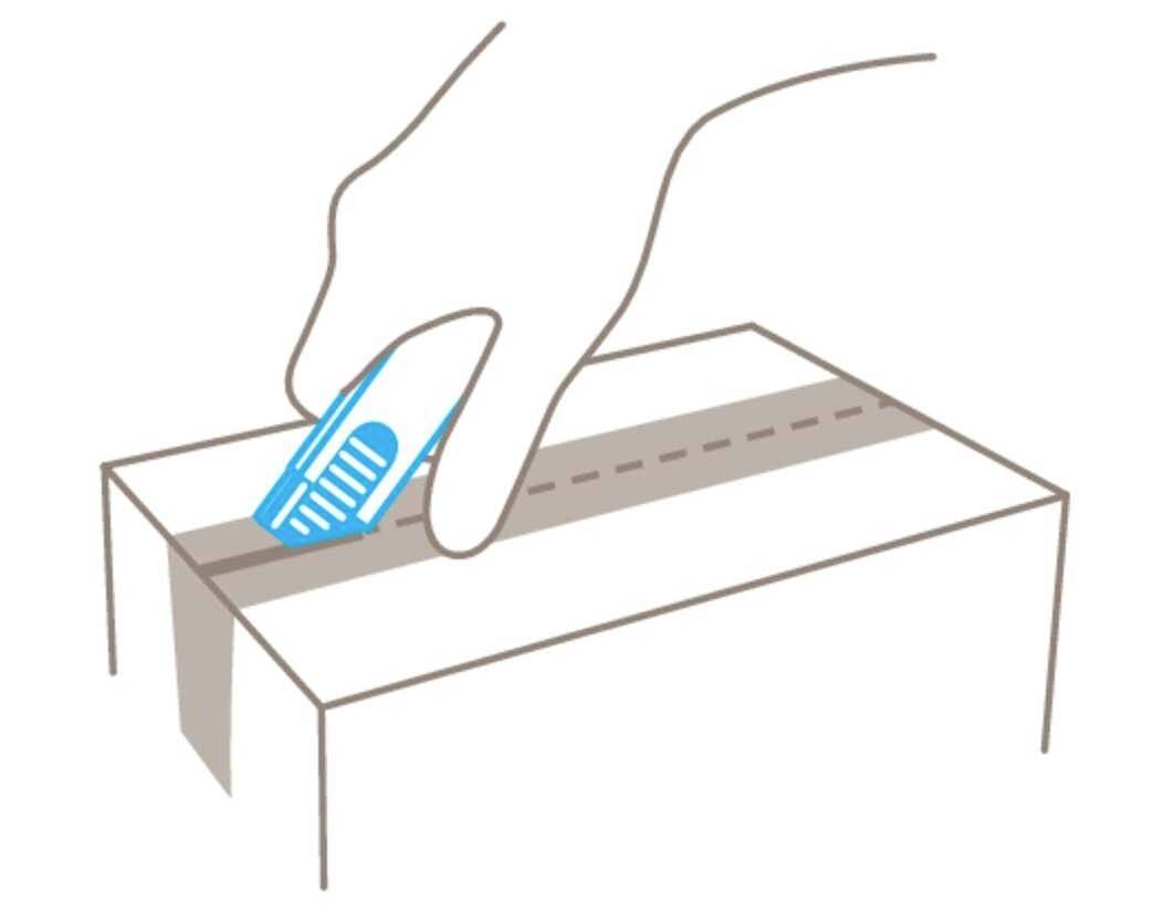 Hand schneidet mit einem Cutter-Messer ein Paket entlang der markierten Linie auf.
