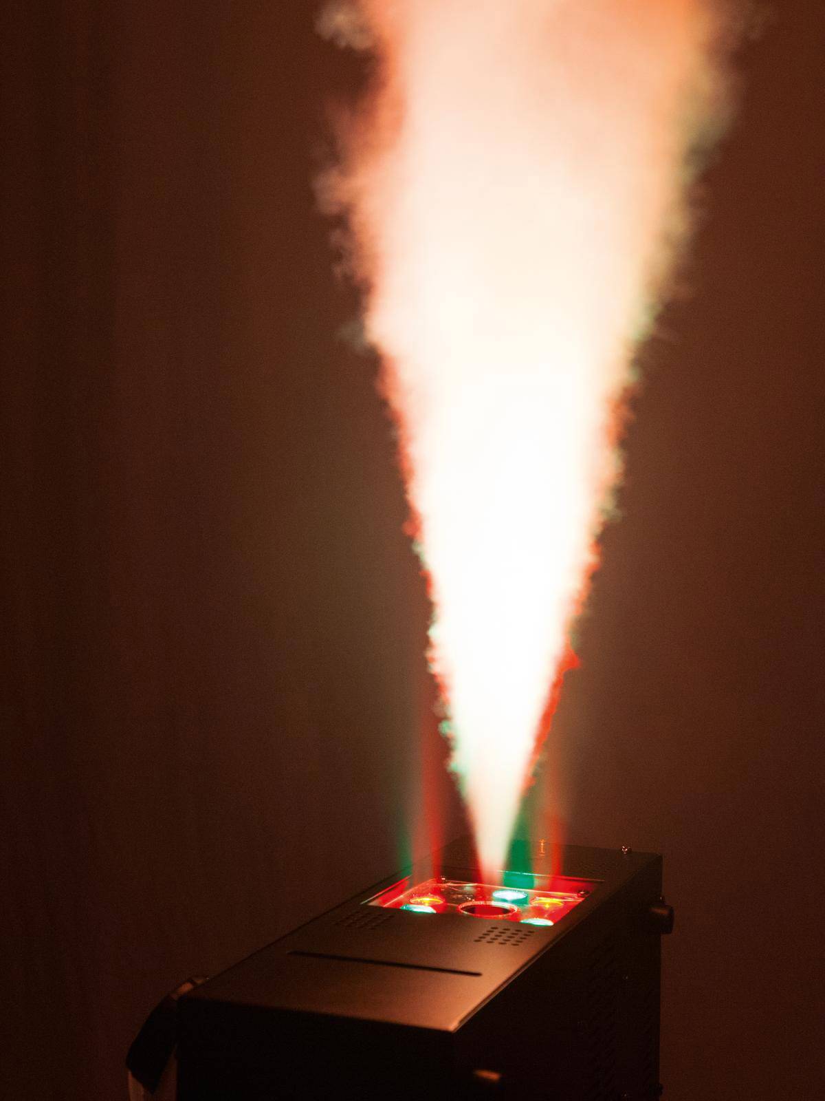 Laser-Effektgerät mit Nebel, das rote und grüne Strahlen erzeugt, die einen atmosphärischen Lichtstrahl in den Raum projizieren.