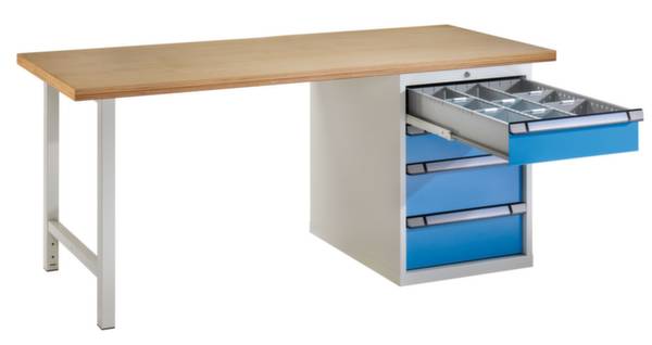 Ein Werktisch mit einer Holzplatte und einem Metallgestell. An der Seite befinden sich mehrere Schubladen, eine ist geöffnet und zeigt Fächer.