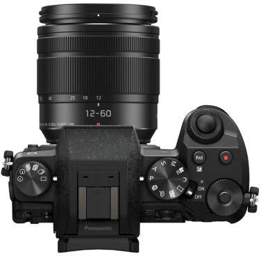 Digitalkamera mit einem fest angebrachten Objektiv, das eine Brennweite von 12-60 mm zeigt. Kameraansicht von oben mit Bedienelementen sichtbar.