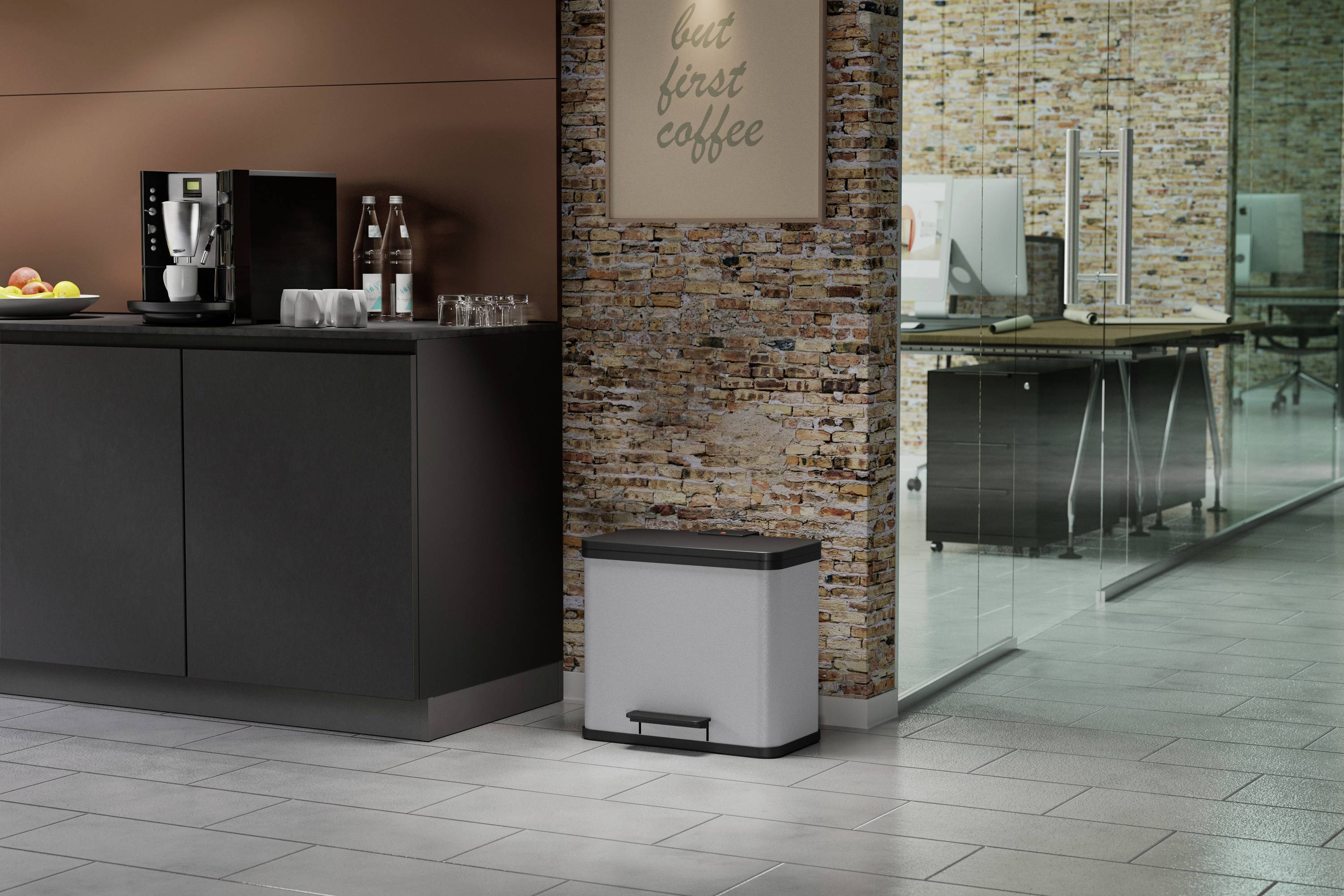 Küche mit Kaffeemaschine, Wasserflaschen und Gläsern auf einem Schrank. Im Hintergrund modernes Büro mit Glaswänden.