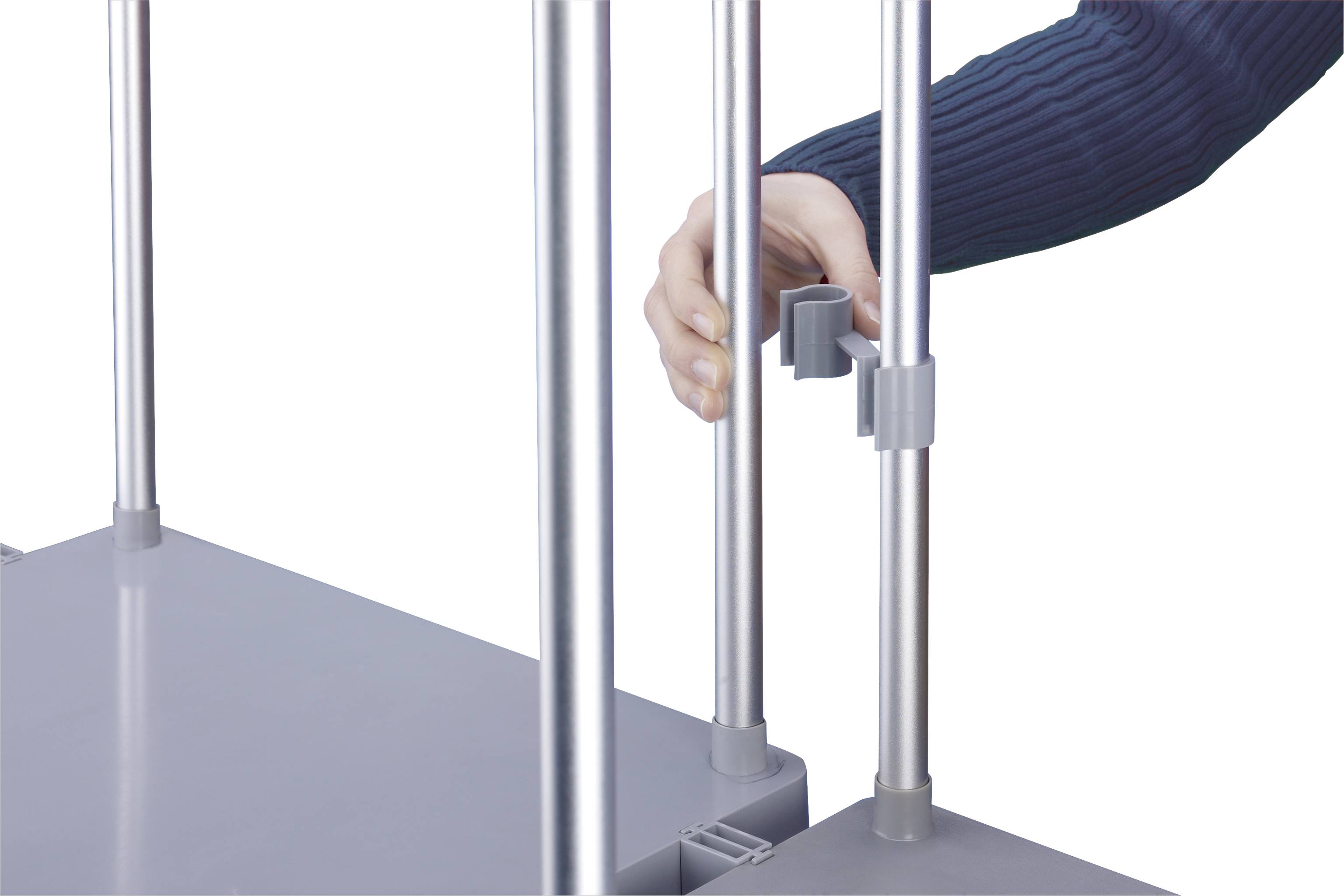 Eine Hand befestigt eine graue Klemmverbindung an einem Metallgestell, das Teil eines Regals zu sein scheint.