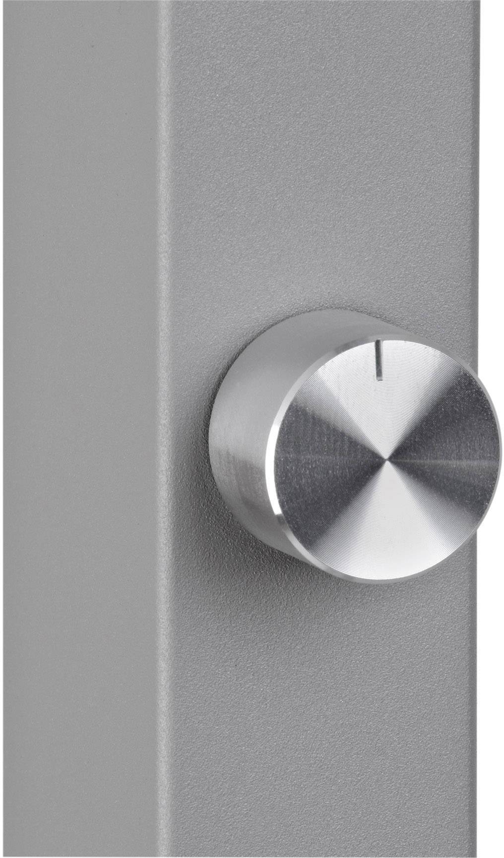 Ein silberner Metallknopf auf einer grauen Oberfläche, möglicherweise ein Bedienelement oder Regler an einem technischen Gerät.