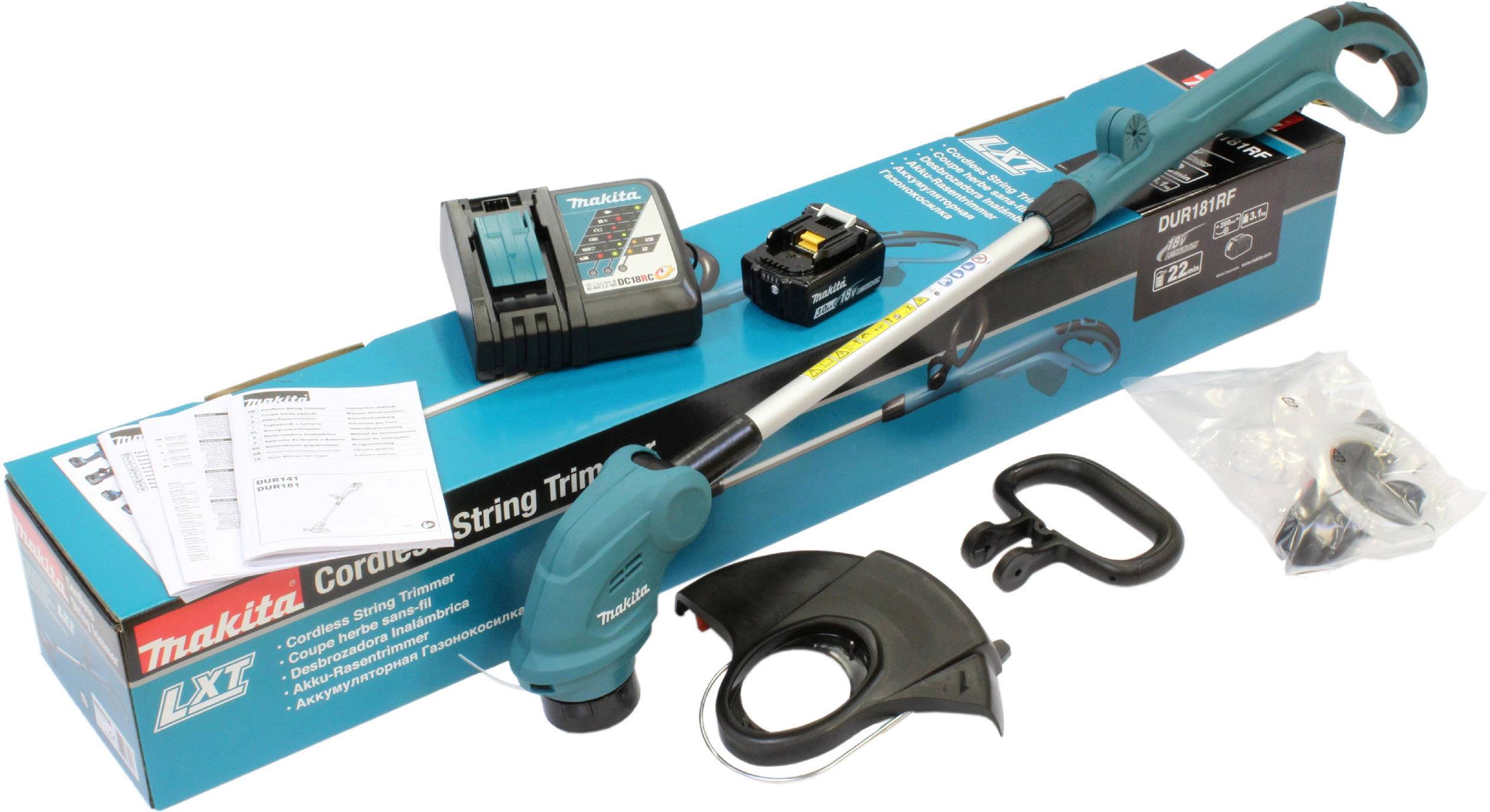 Ein grüner, kabelloser Makita Rasentrimmer mit Zubehör und Verpackung. Enthält Akku, Ladegerät, Schutzabdeckung, Griffe und Anleitungen.