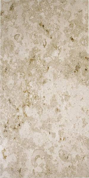Beige Marmoroberfläche mit unregelmäßigen dunklen Flecken und fossilen Einschlüssen.
