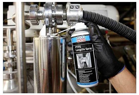 Eine Person, die einen schwarzen Handschuh trägt, verwendet „Liqui Moly PTFE Longlife Spray