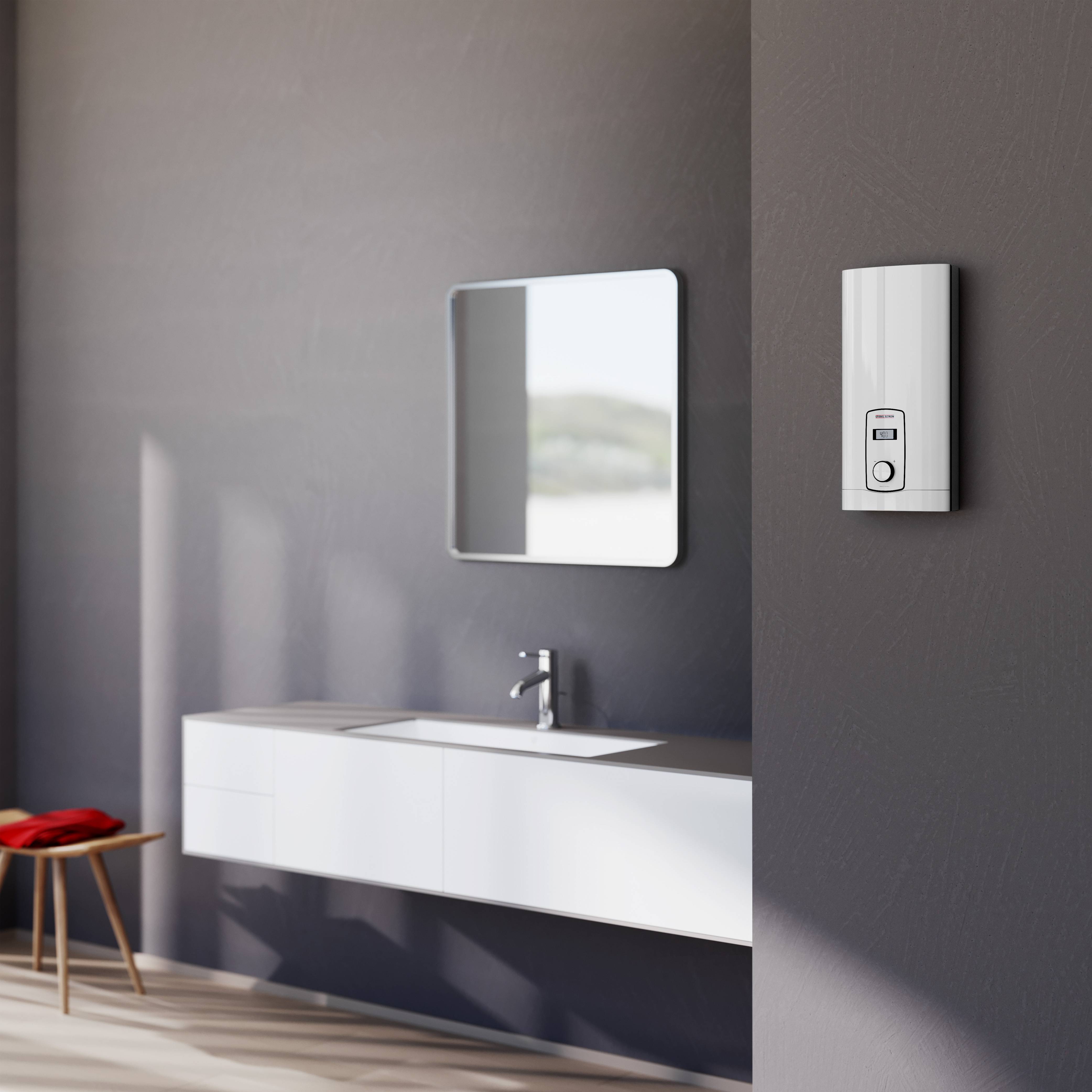 Modernes Badezimmer mit Spiegel, Wandwaschbecken und modernem Wassererhitzer an grauer Wand. Ein roter Hocker steht daneben.