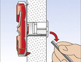 Eine Person zieht an einem roten Hebel, der in eine Halterung an einer Wand eingesteckt ist. Der Hebel wird nach links gedreht.