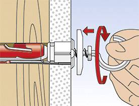 Eine Hand zieht einen Metallhaken, der in einer Wandbefestigung verankert ist, heraus. Darstellung der korrekten Montage.