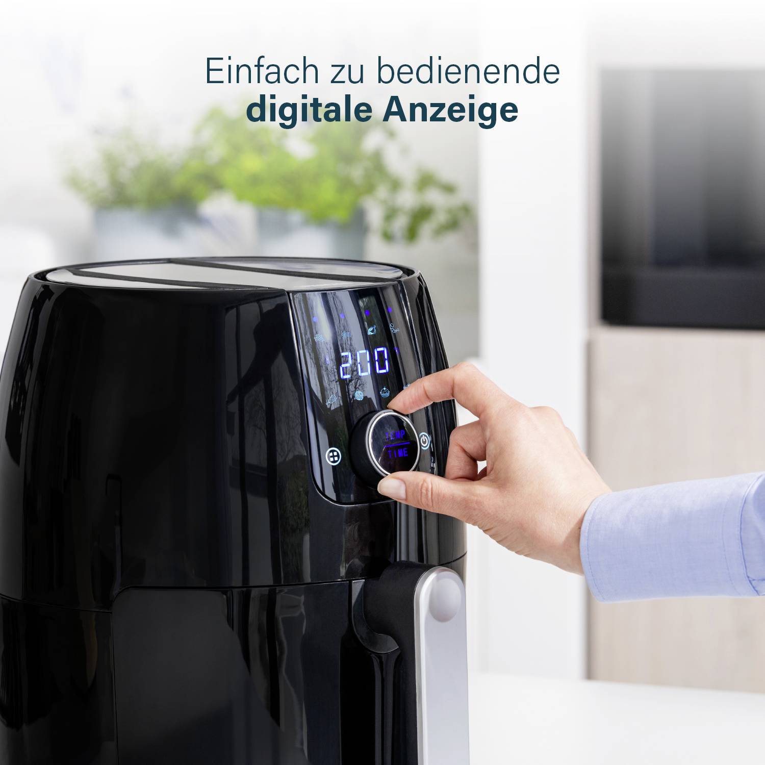 Eine Person bedient einen digitalen Bildschirm auf einer schwarzen Heißluftfritteuse. Text oben: 'Einfach zu bedienende digitale Anzeige'.