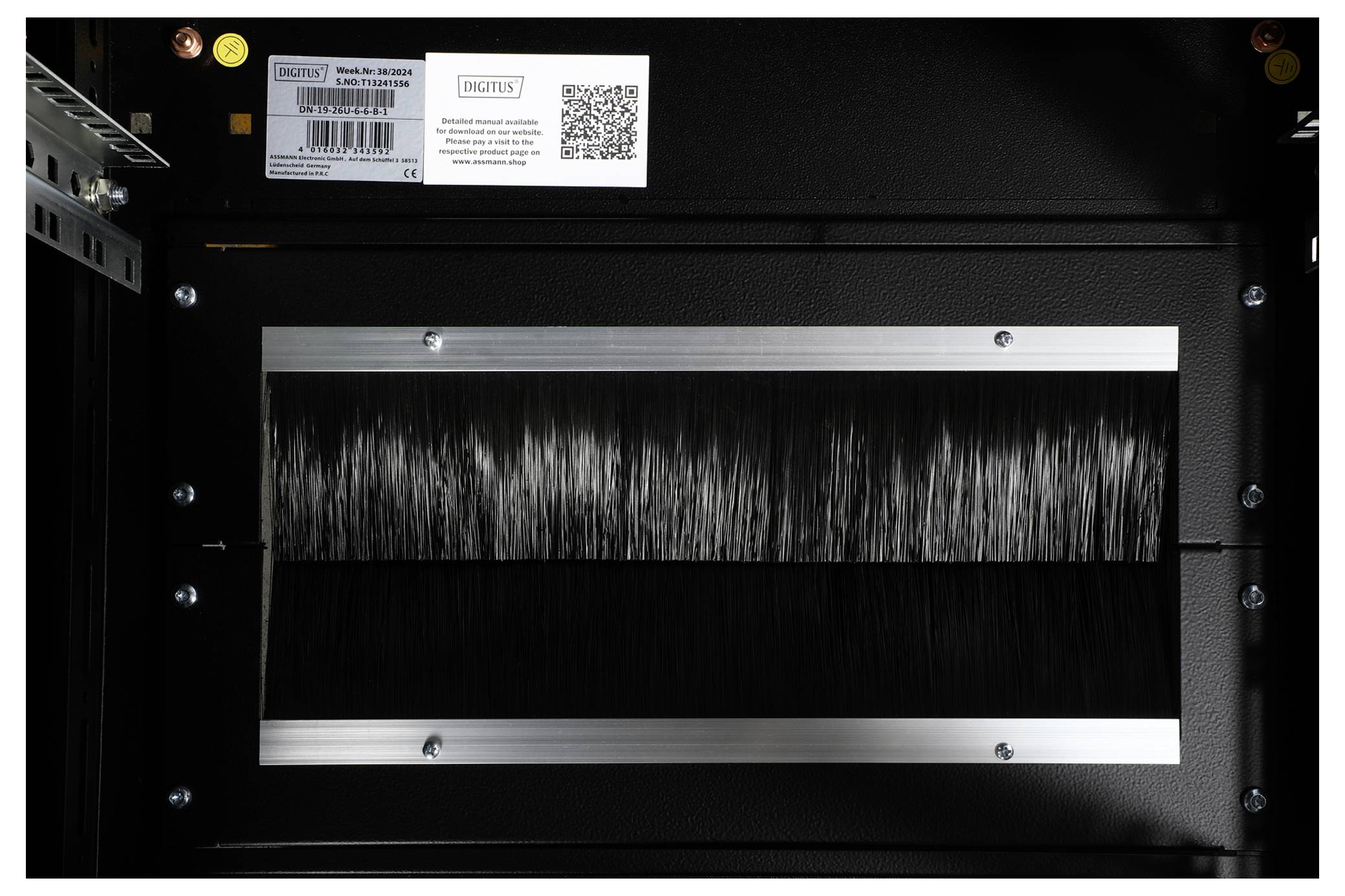 Ein schwarzes Rechteck mit vertikalen Borsten, eingerahmt von einem metallischen Rand, in einem Computergehäuse.