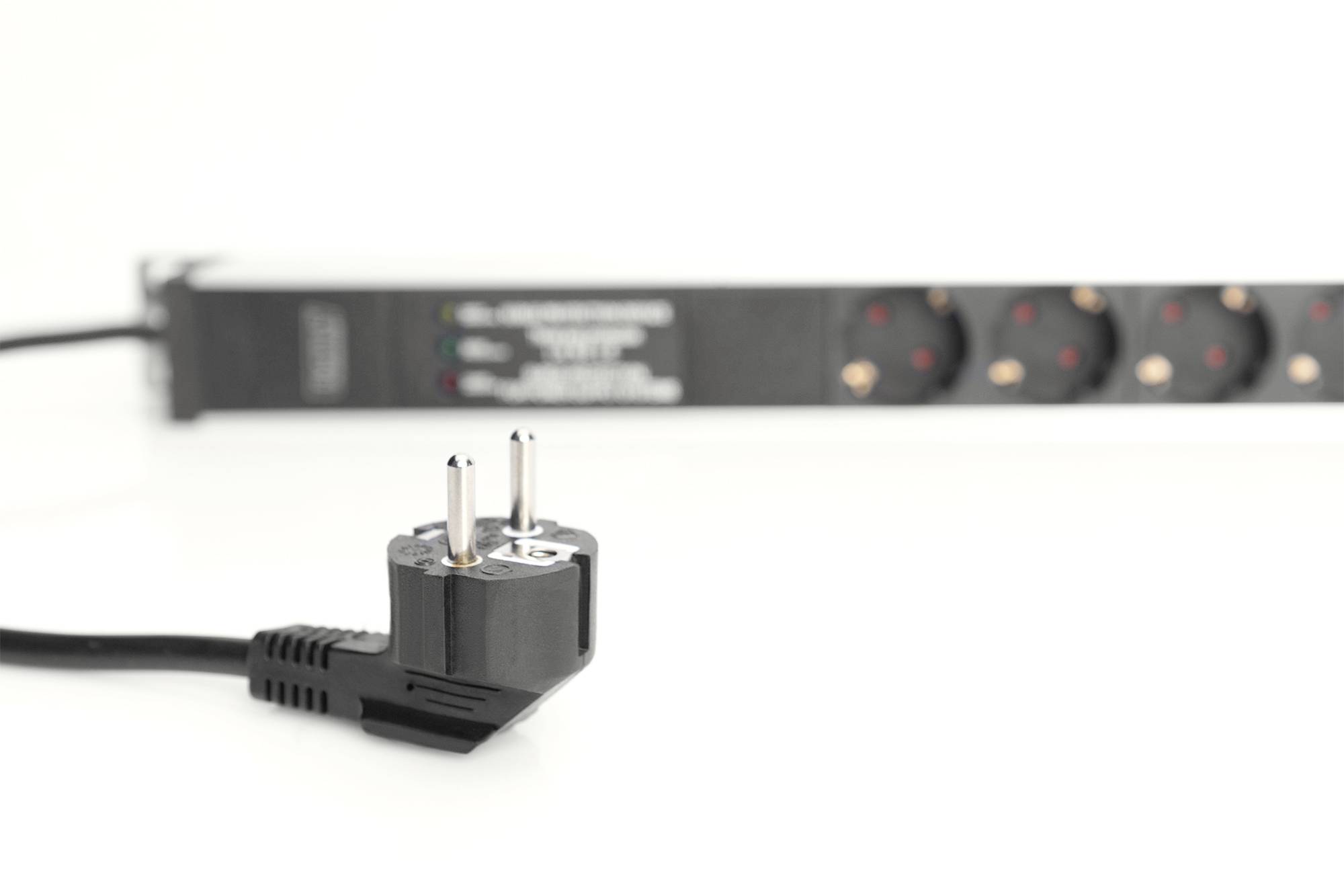 Ein Stromstecker liegt im Vordergrund, unscharfe Steckdosenleiste im Hintergrund. Der Fokus liegt auf der Stromversorgung.