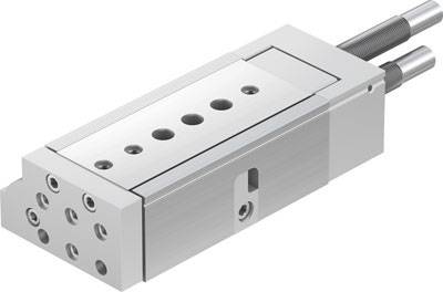 Ein rechteckiger Pneumatikzylinder aus Metall mit mehreren Anschlussöffnungen. Schrauben sind an einer Seite sichtbar.