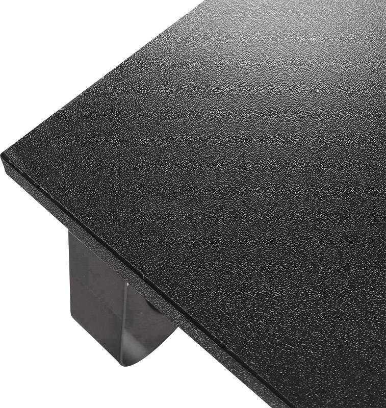 Ein schwarzer Tisch mit einer strukturierten Oberfläche und Metallbeinen, in einer Ecke von oben fotografiert.