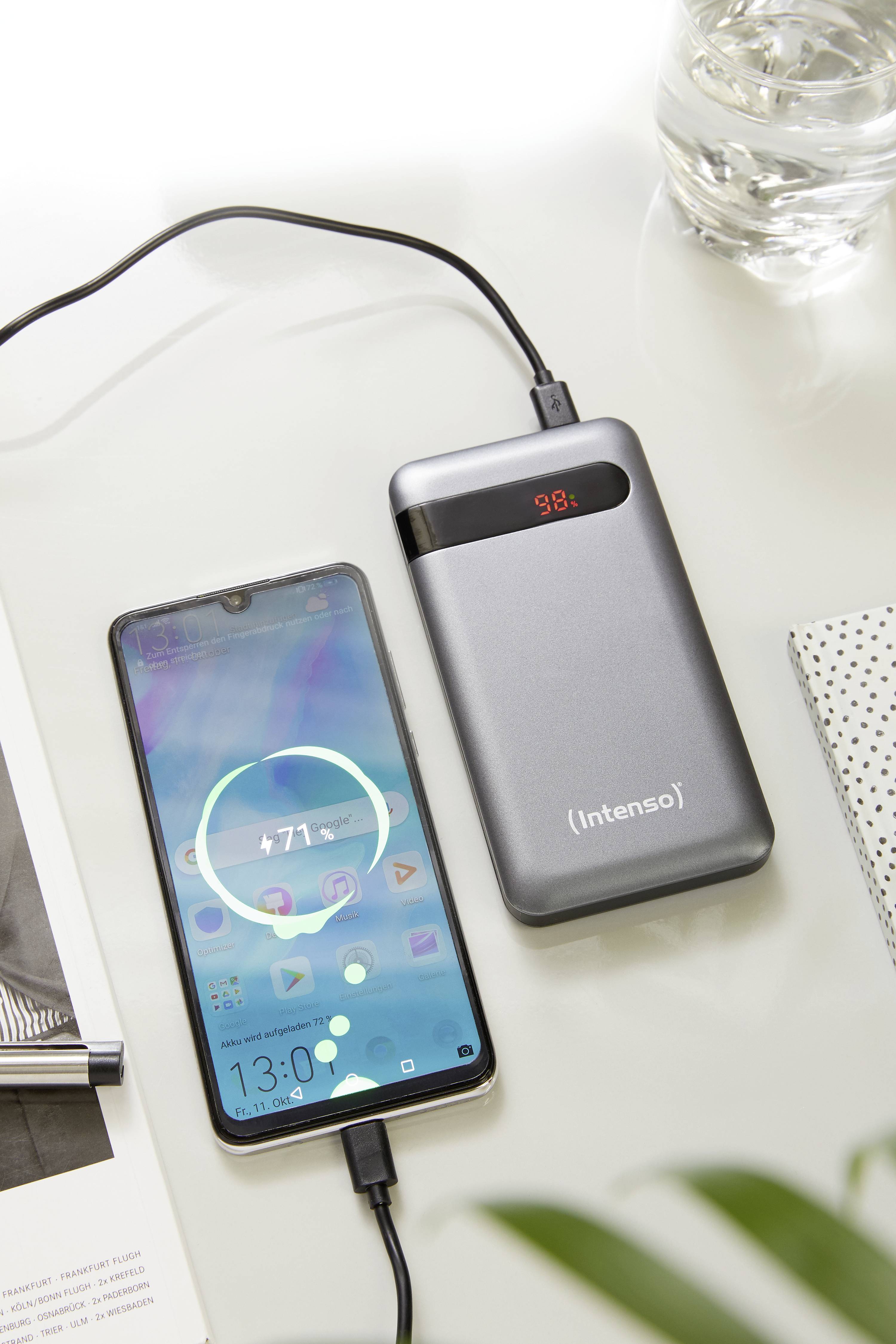 Ein Smartphone wird mit einer silbernen Powerbank von 'Intenso' geladen. Auf dem Display des Handys ist ein Ladeprozess angezeigt.