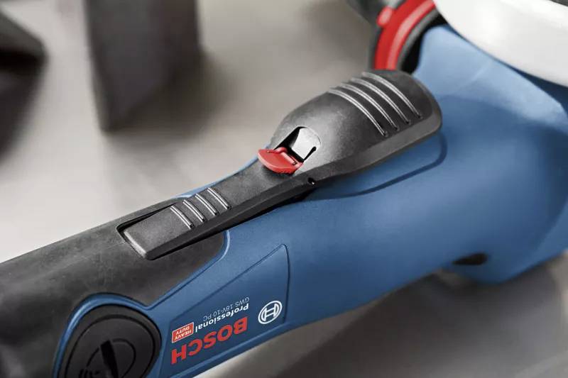 Nahaufnahme eines blauen Bosch-Werkzeugs mit rotem Schalteraufsatz. Der Fokus liegt auf dem ergonomischen Design des Griffes.