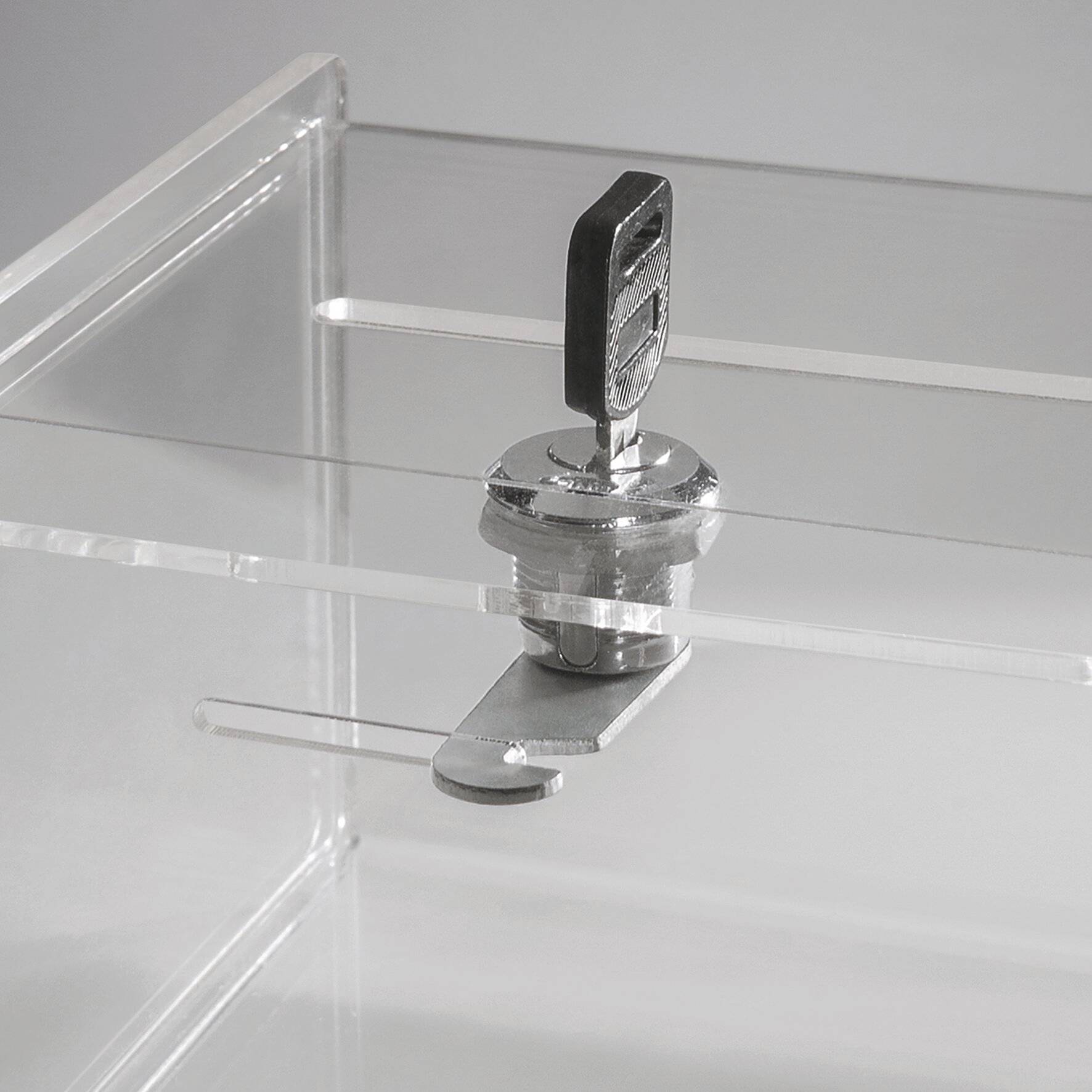 Eine transparente Acrylbox mit einem Metallschlüssel, der in ein Schloss auf ihrer Oberseite eingesetzt ist und einen sicheren, verschließbaren Behälter andeutet.