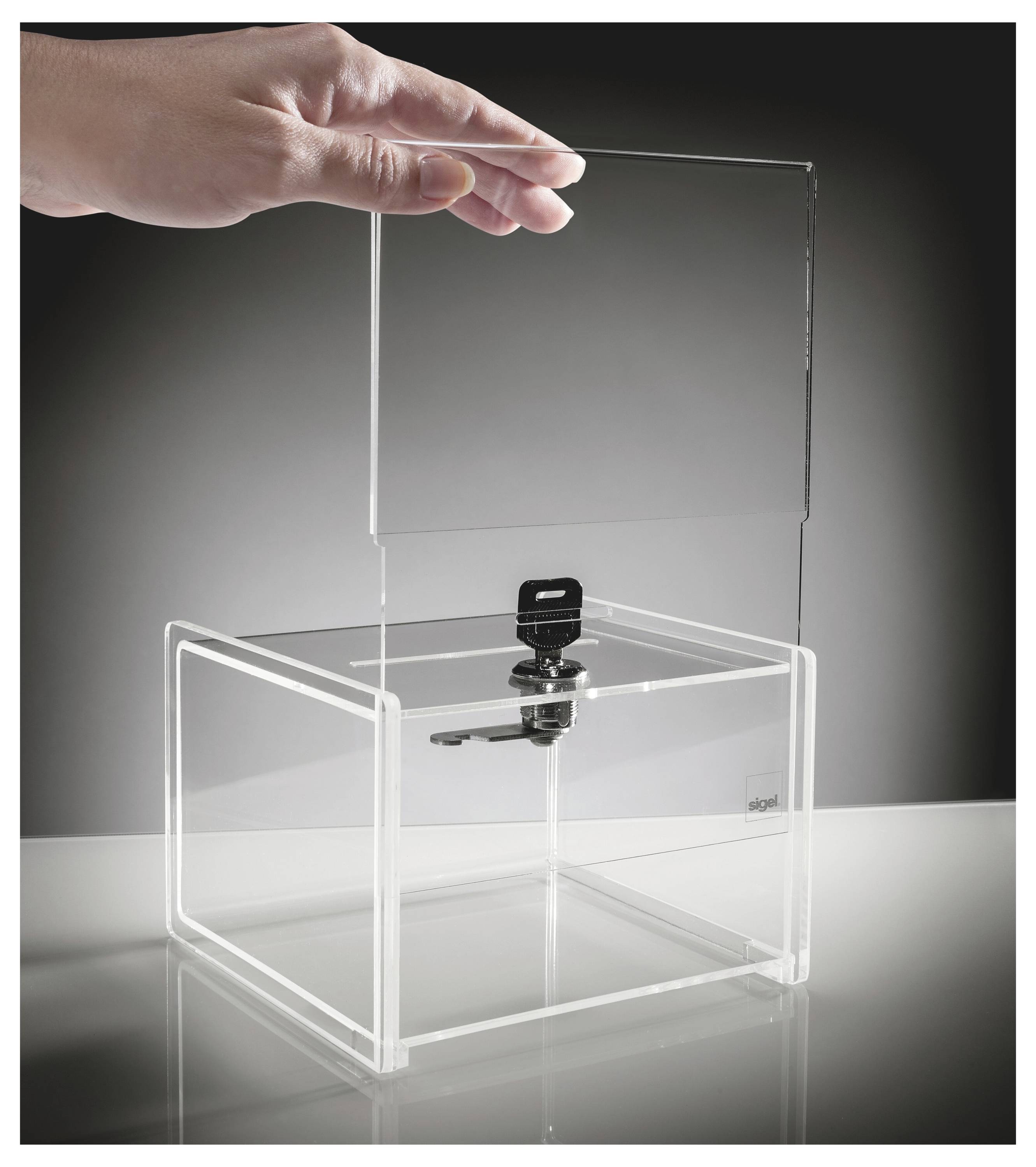 Hand, die einen transparenten Acryldeckel auf eine durchsichtige Vitrine mit einer zentralen schwarzen Verriegelung oder Verschluss setzt.