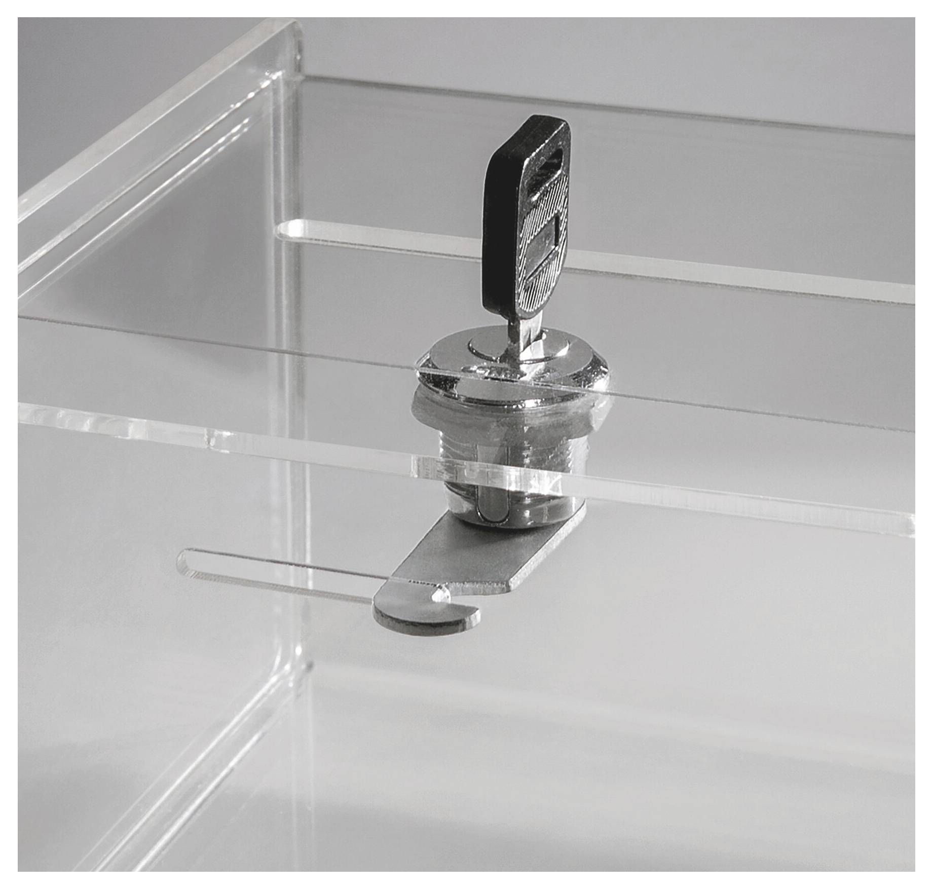 Nahaufnahme eines transparenten Acryl-Vitrinenschlosses mit einem schwarzen Schlüssel, der eingeführt ist und den durchsichtigen Deckel sichert.