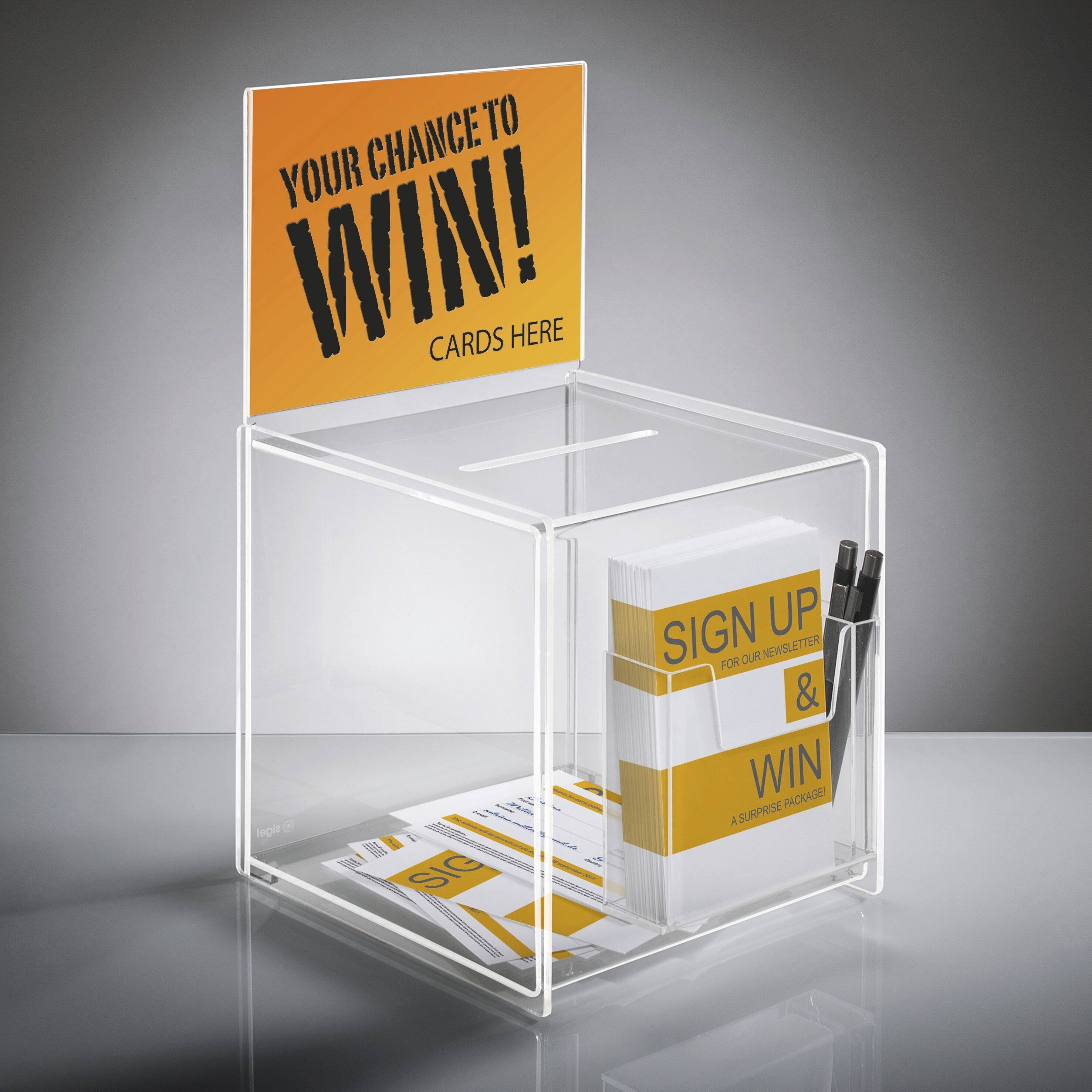 Eine transparente Wettbewerbseinwurfbox mit einem Schild darüber, auf dem steht: 