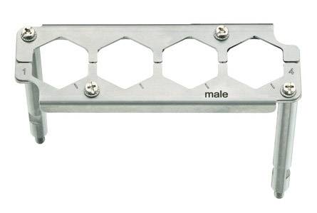 Metallhalterung mit vier hexagonalen Aussparungen; markiert mit 'male'. Schrauben sind an den Ecken befestigt.
