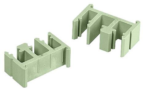 Zwei grüne Kunststoffteile, rechteckig mit mehreren Aussparungen, liegen nebeneinander. Sie könnten Teile eines modularen Systems sein.