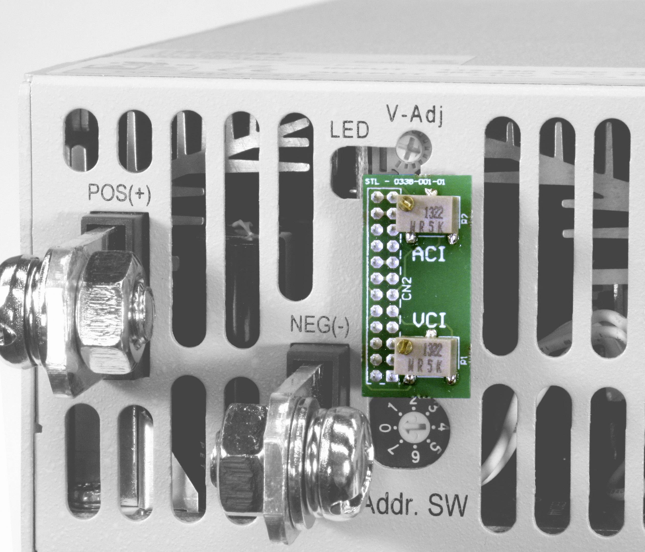 Nahaufnahme eines elektronischen Geräts mit Anschlüssen und einer grünen Schaltung mit den Aufschriften 'ACI' und 'UCI'.