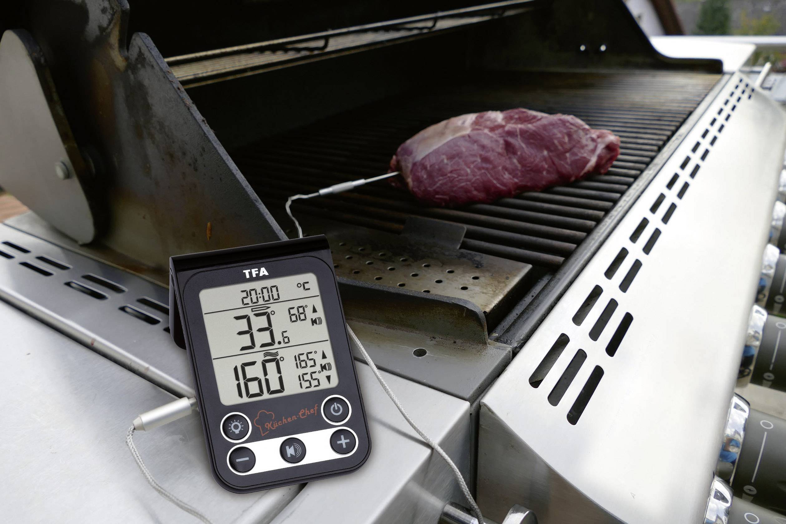 Digitale Grillthermometeranzeige zeigt 33,6°C und Zieltemperatur 68°C an. Fleischstück auf Grill mit Messfühler verbunden.