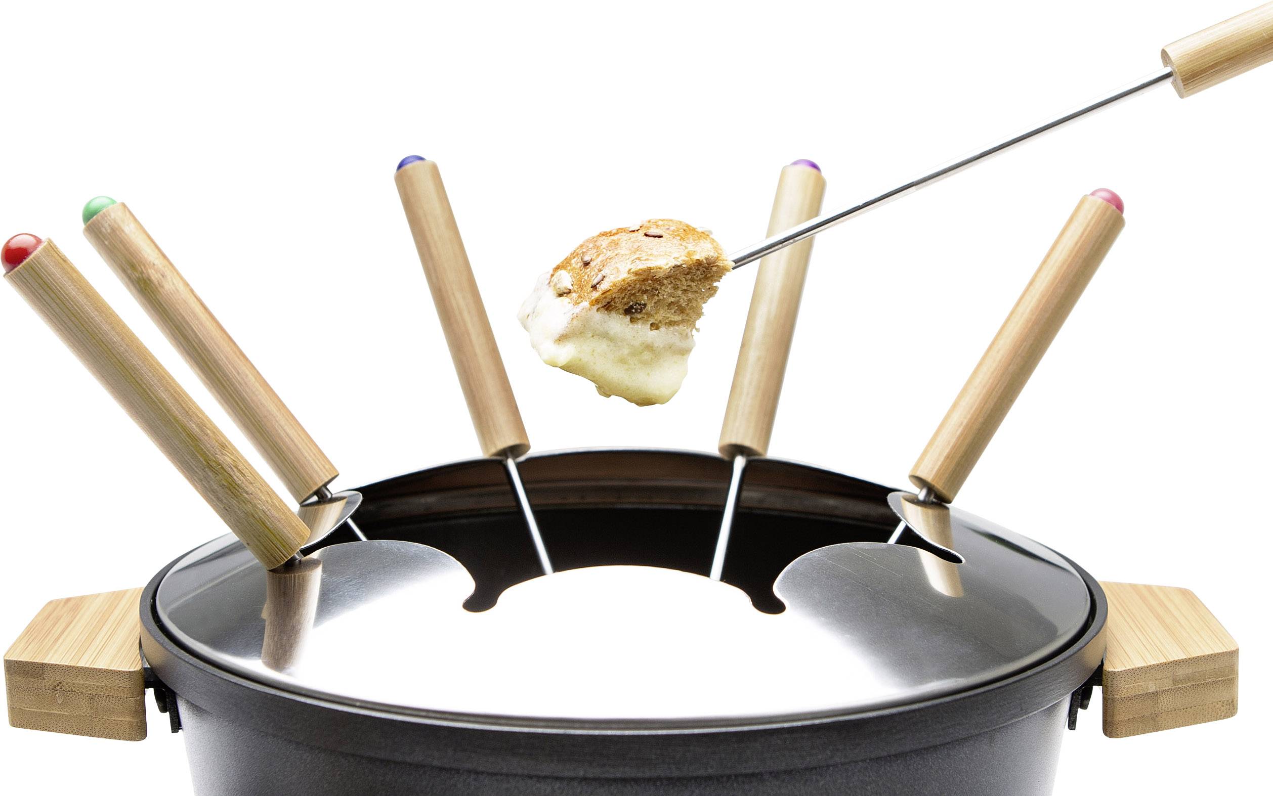 Mehrere Fondue-Gabeln stecken in einem Topf. Eine Gabel hält ein Stück Brot mit geschmolzenem Käse darüber.