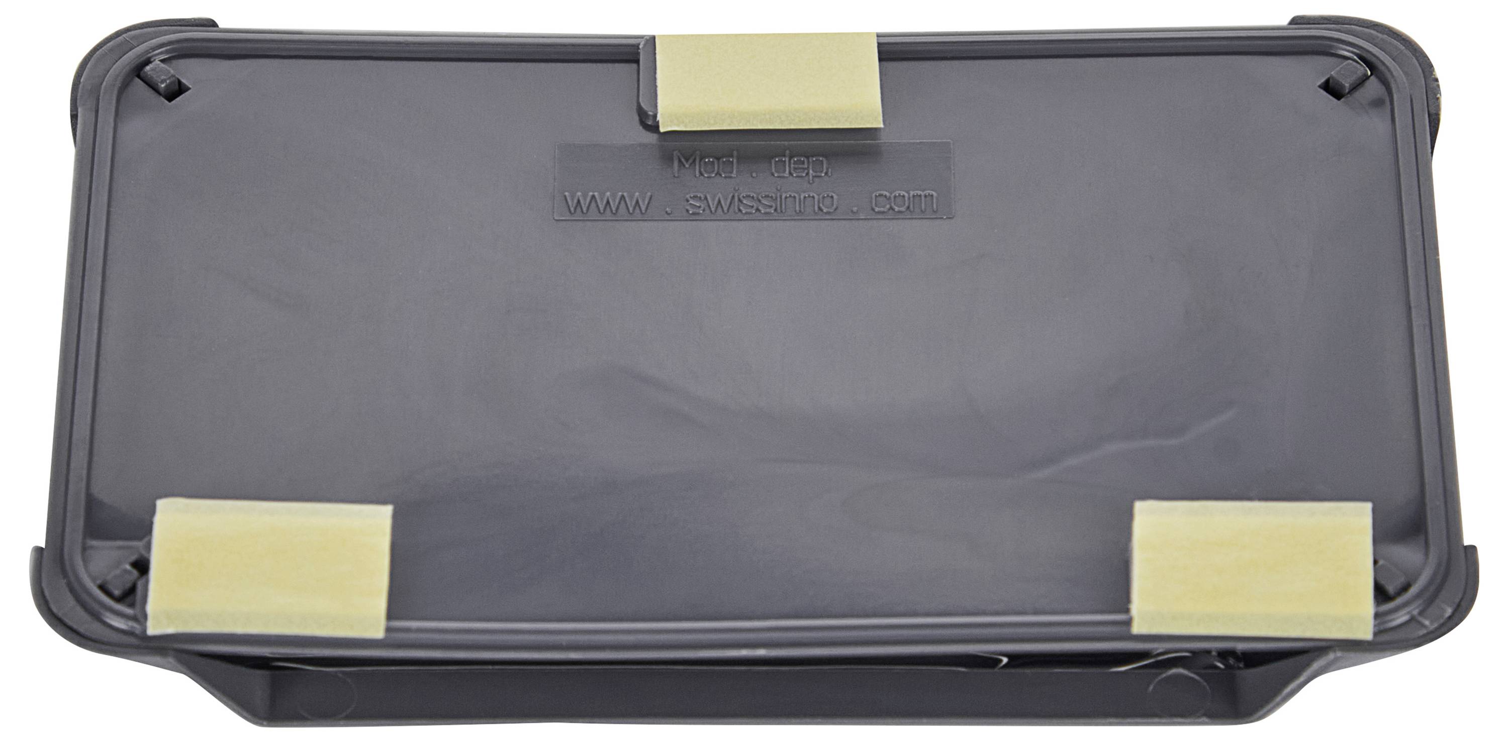 Eine rechteckige schwarze Kunststoffabdeckung mit drei beigen Schaumpolstern, die oben befestigt sind. Der Text 'SW6' und eine Webseiten-URL sind in der Mitte geprägt.