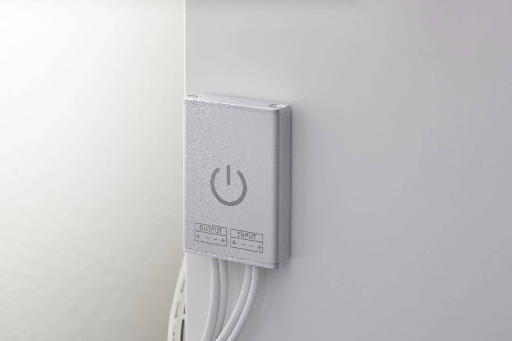 Ein weißer Schalter mit einem Power-Symbol, befestigt an einer Wand, mit Kabeln, die unten herausführen.